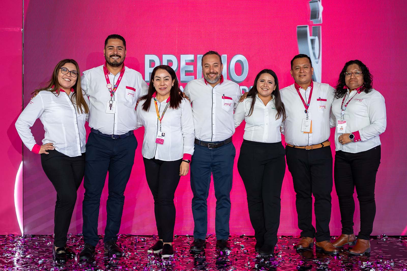 Equipo de Compartamos Banco posando en el escenario del evento.