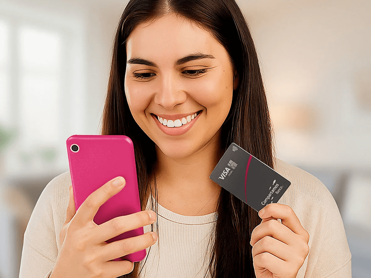 Mujer sosteniendo tarjeta compartamos junsto a móvil